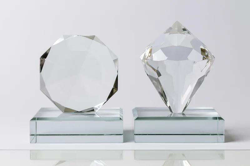 Two blank crystal glass trophies side by side on clear bases