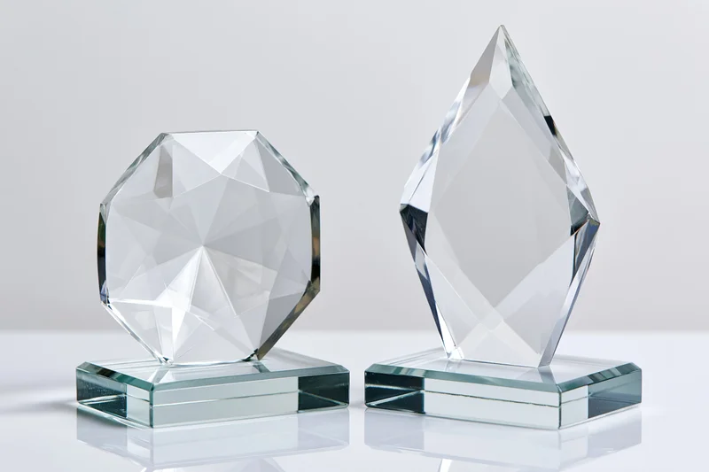 Two blank crystal glass trophies side by side on white surface