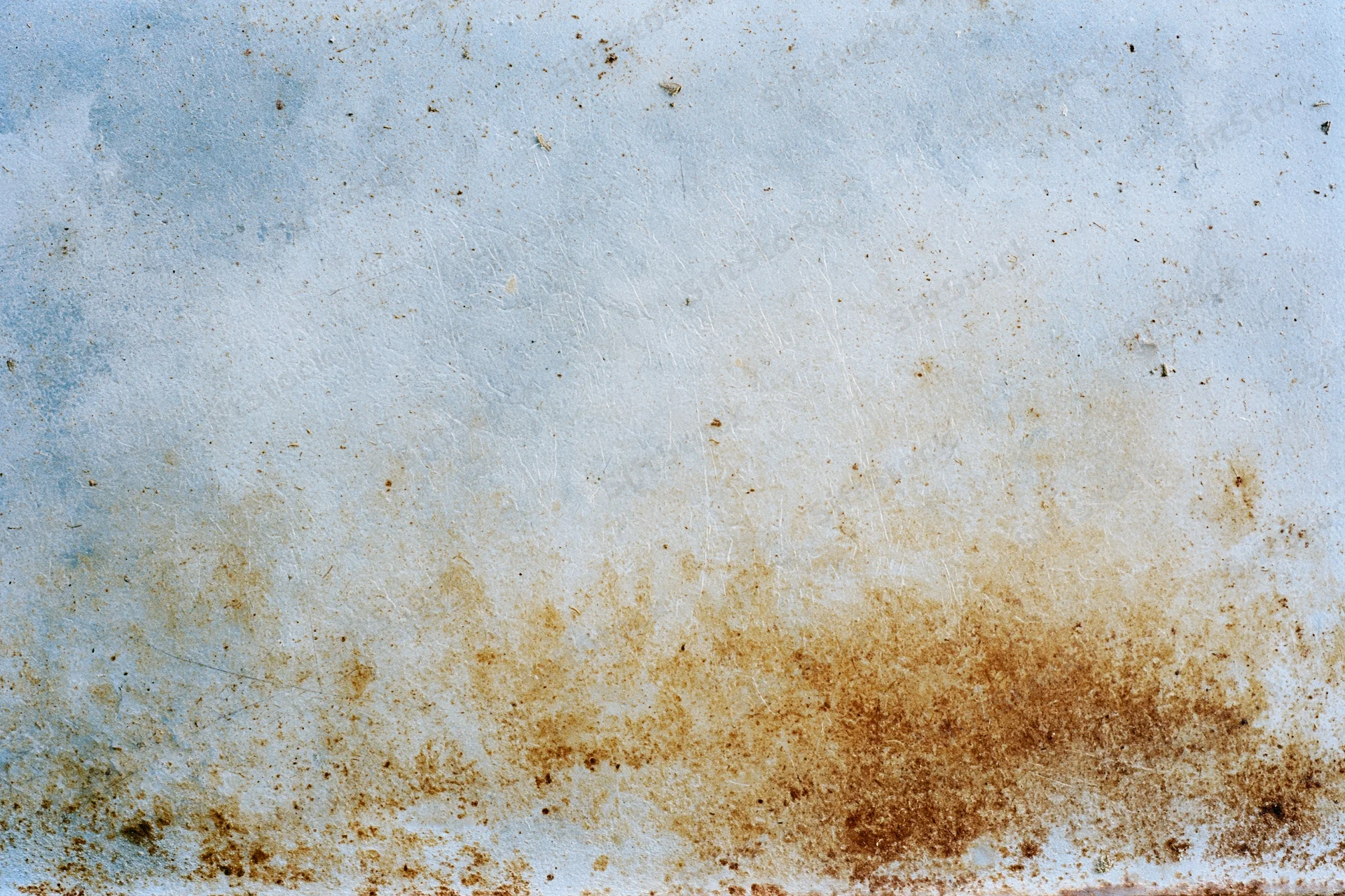 Weathered metal surface with rust stains and blue-gray paint, flat-lay close-up view
