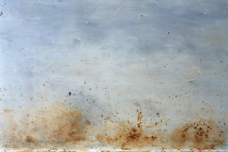 Weathered metal surface with rust and scratches showing signs of corrosion and wear