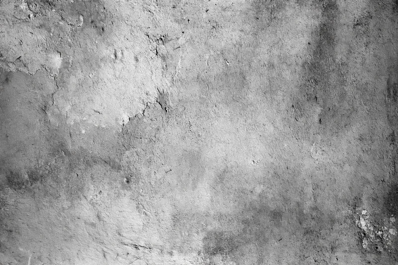 Weathered concrete wall surface filling the frame with cracks and peeling texture