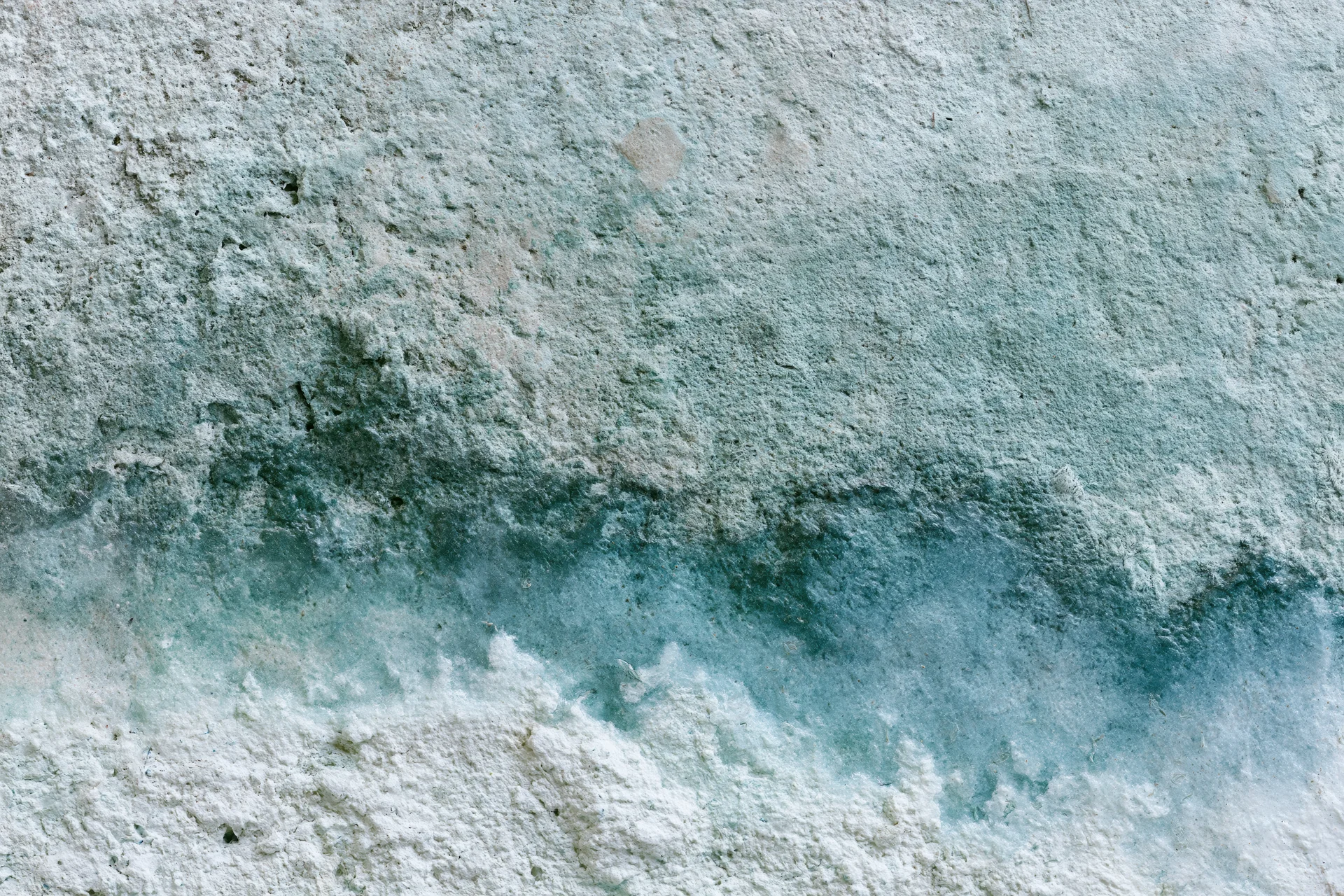 Weathered concrete wall surface with water stains and mineral discoloration