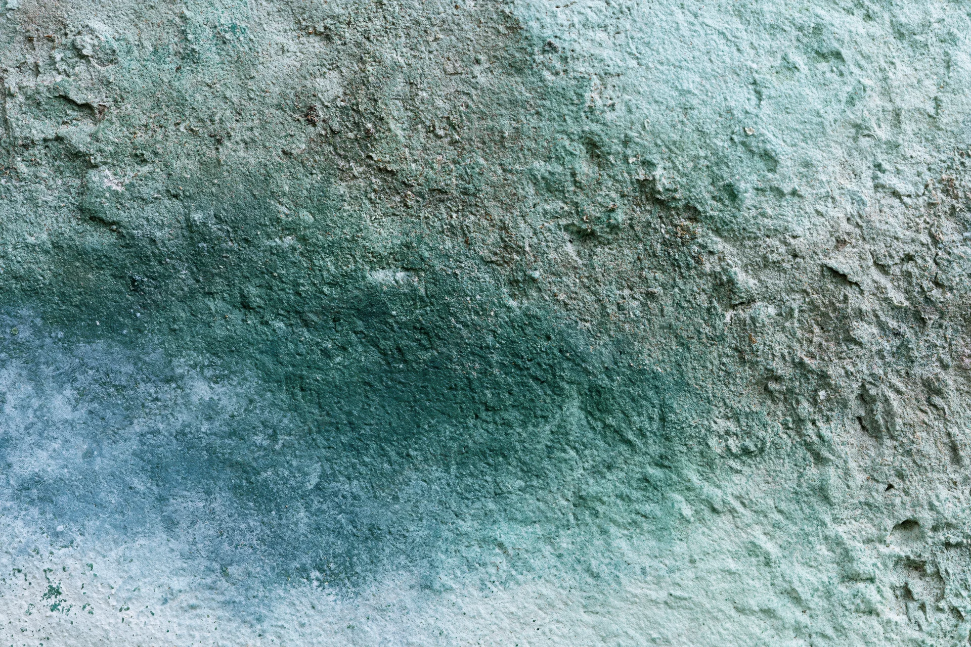Weathered concrete wall surface with water stains and mineral discoloration
