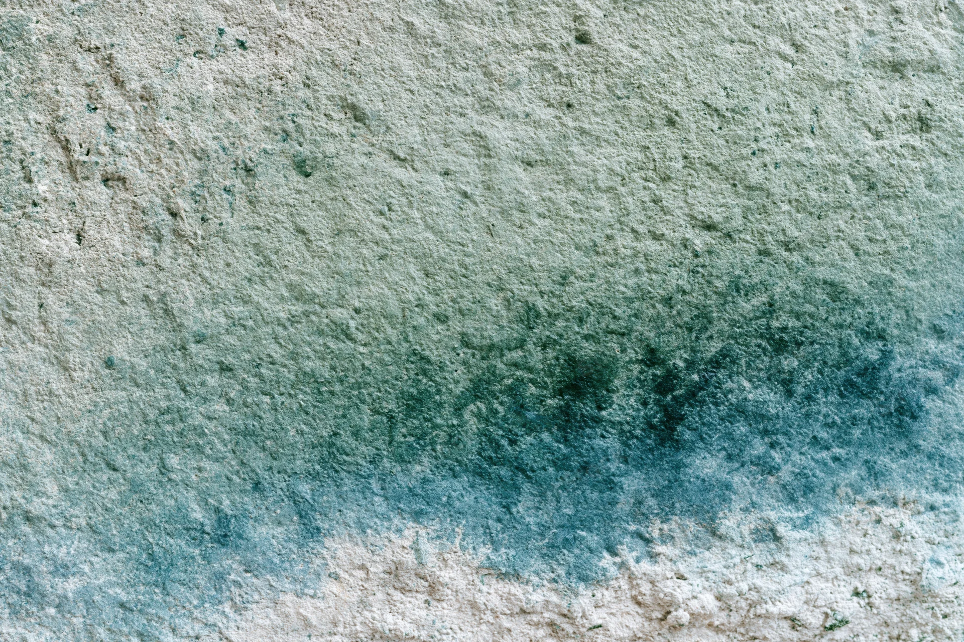 Weathered concrete wall surface with water stains and mineral discoloration