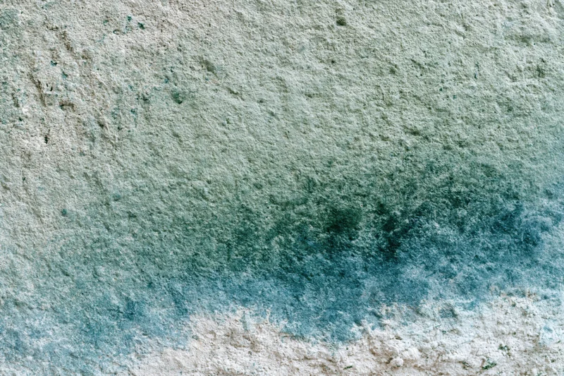 Weathered concrete wall surface with water stains and mineral discoloration