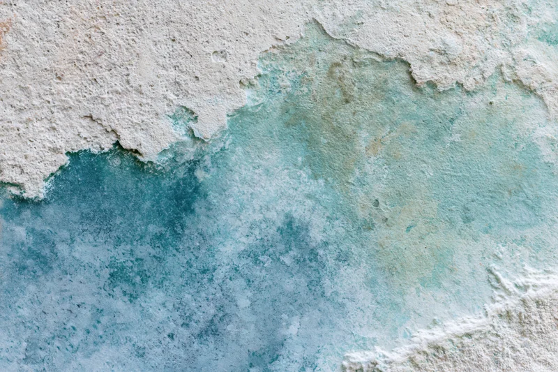 Weathered concrete wall surface with water stains and mineral discoloration