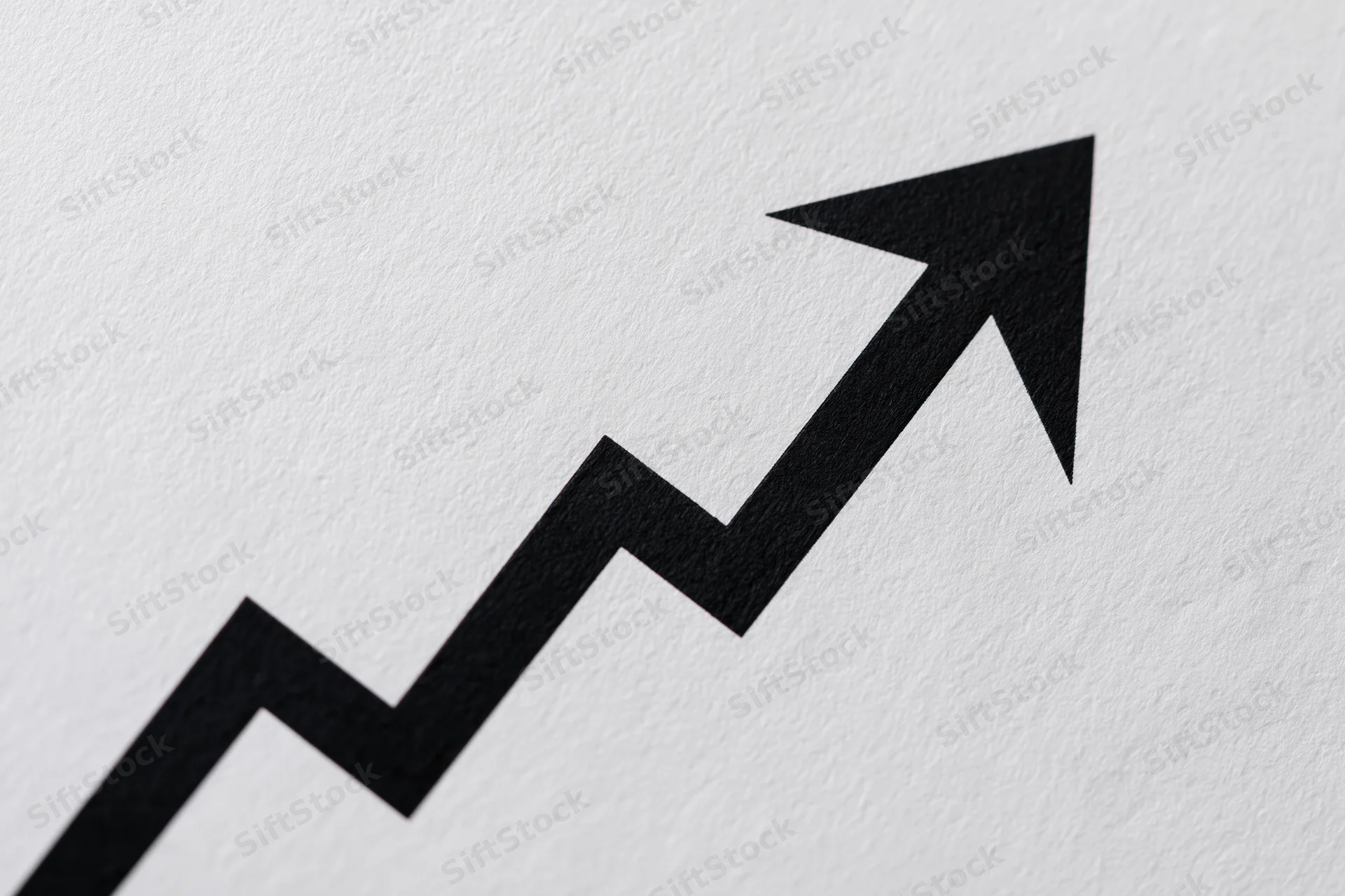 Bold black zigzag arrow rising diagonally on textured white paper
