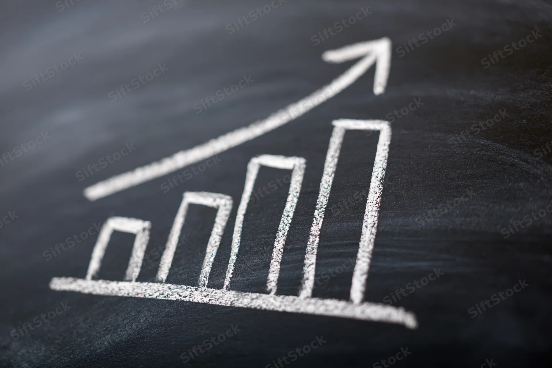 Hand-drawn chalk bar chart with upward arrow on blackboard