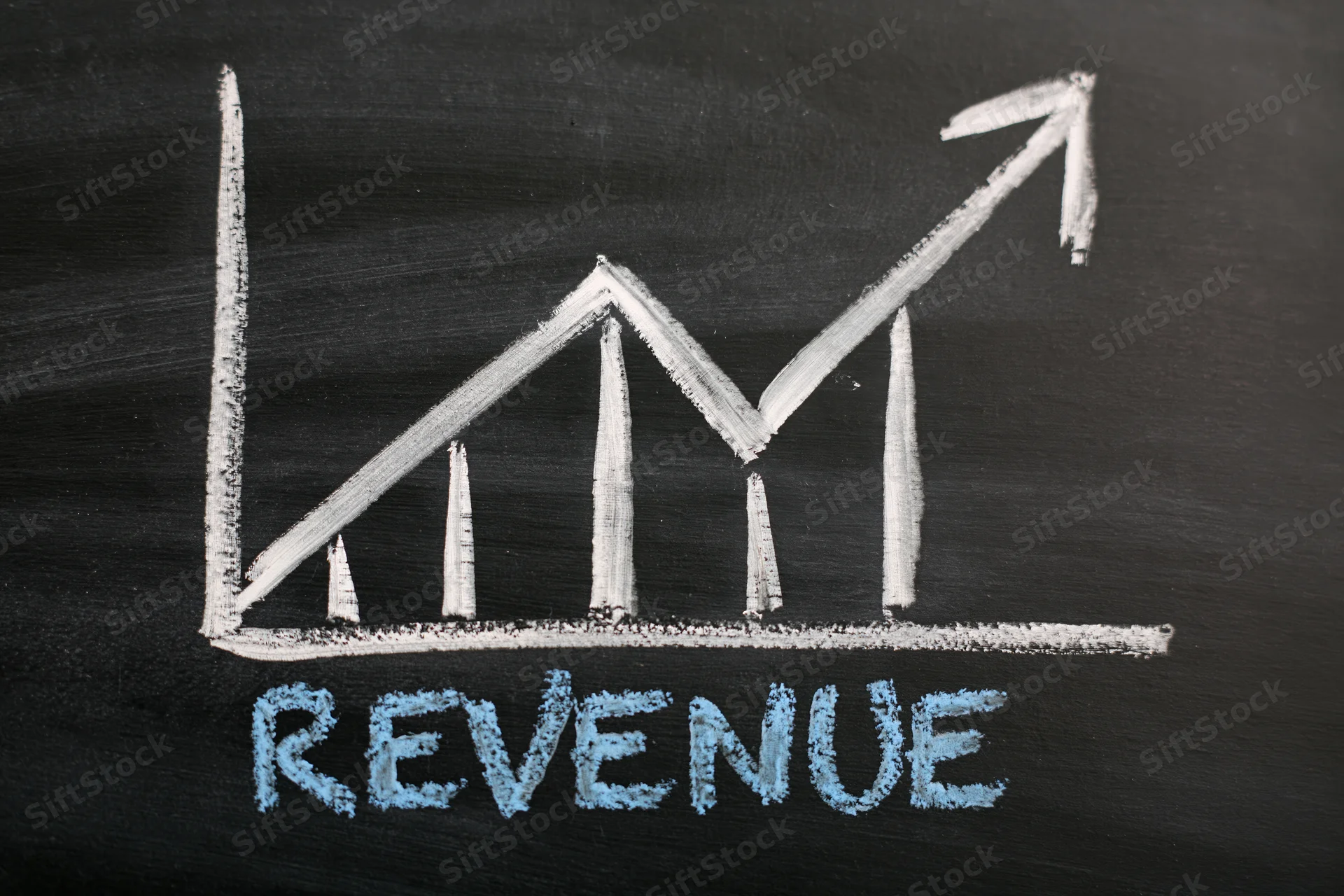 Hand-drawn chalk graph showing upward revenue trend on blackboard