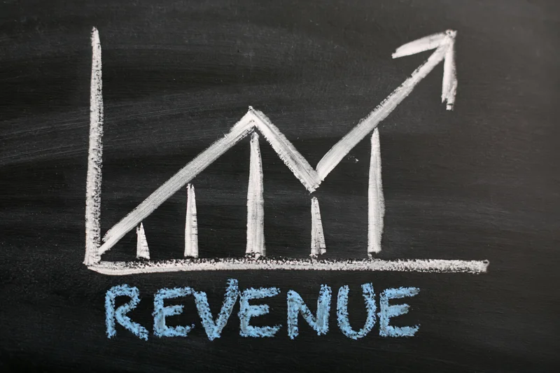 Hand-drawn chalk graph showing upward revenue trend on blackboard