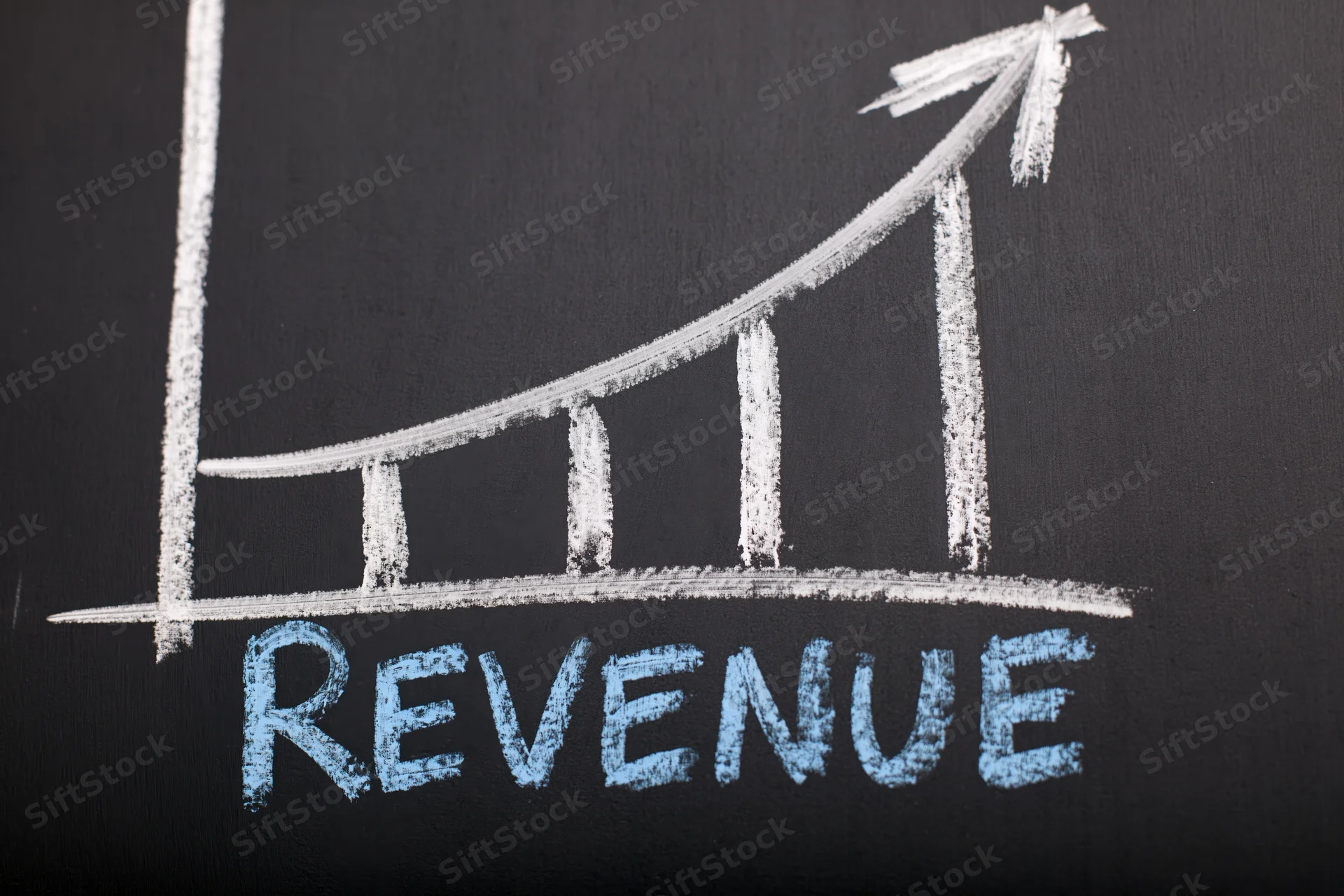 Upward trending revenue graph drawn in chalk on a blackboard