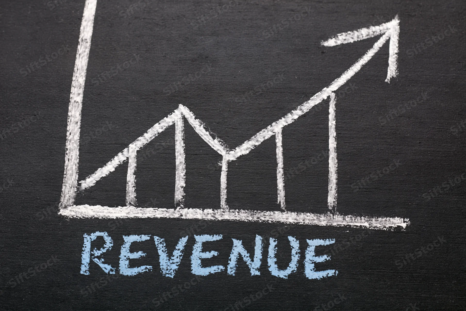 Hand-drawn chalk graph showing upward revenue trend on blackboard