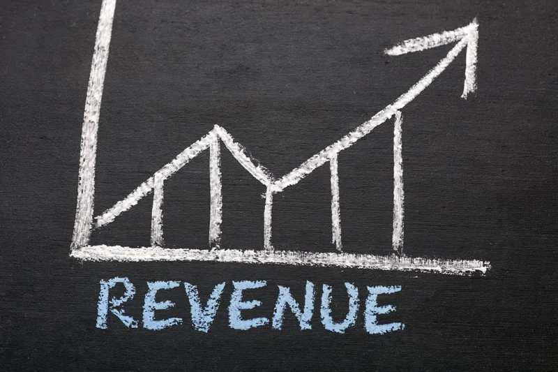 Hand-drawn chalk graph showing upward revenue trend on blackboard