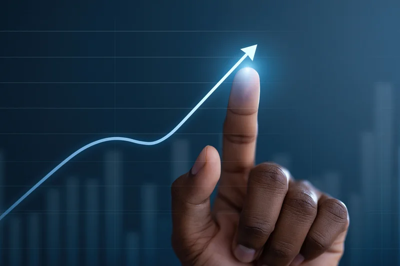 Hand pointing upward at glowing arrow on digital graph display
