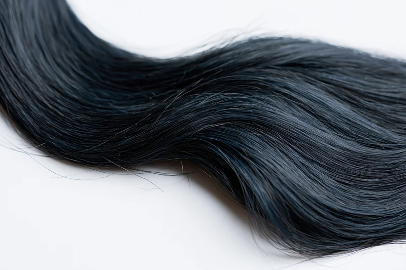 Flowing wave of dark black hair isolated on white background