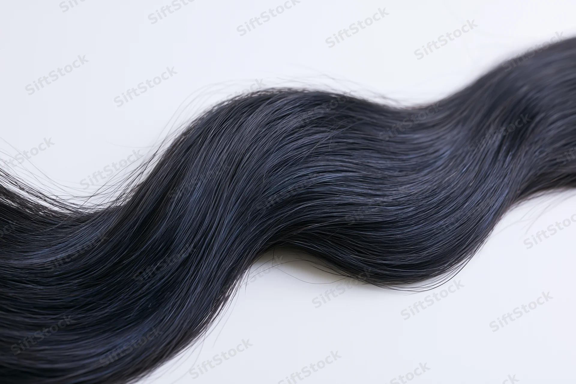 Flowing wave of dark black hair isolated on white background