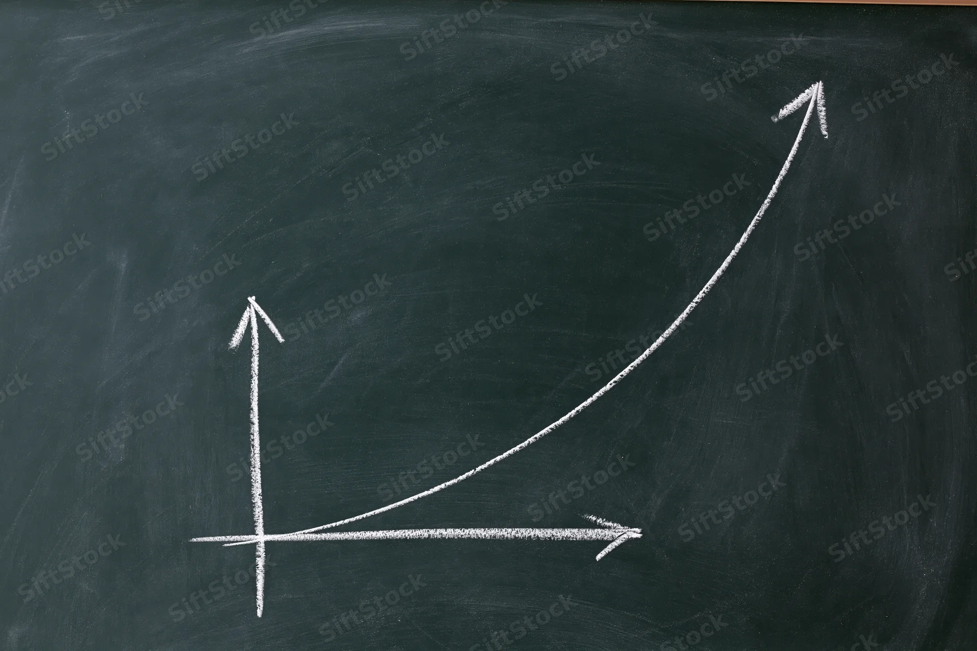 Exponential growth curve drawn in white chalk on a blackboard