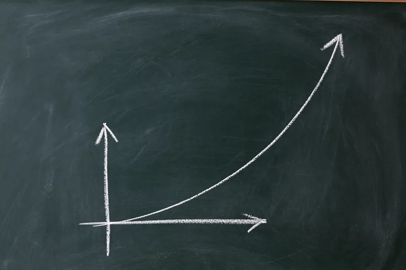 Exponential growth curve drawn in white chalk on a blackboard