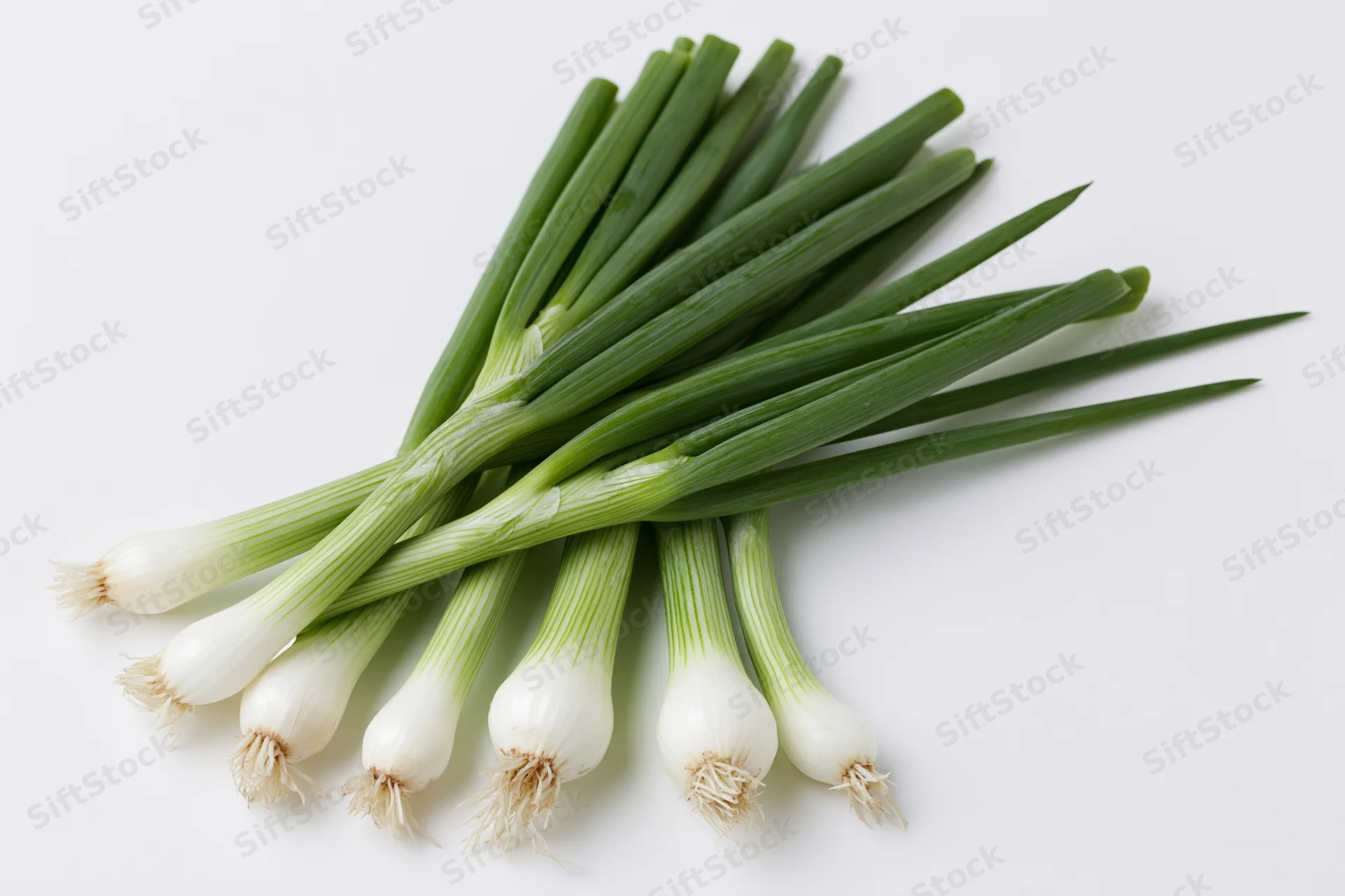 A small bunch of fresh green onions with white bulb ends and green stems arranged on a white surface
