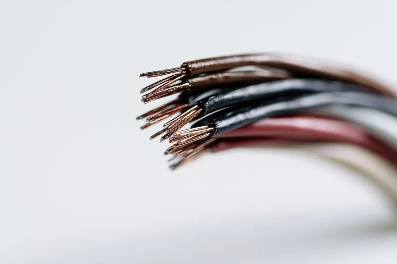 Closeup of stripped multicolored electrical wires fanning out against white background