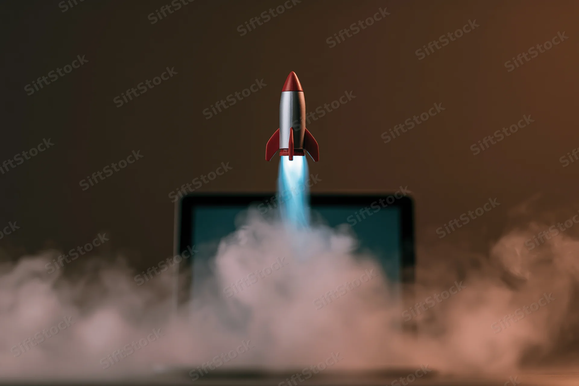 Small rocket launching from laptop screen surrounded by smoke