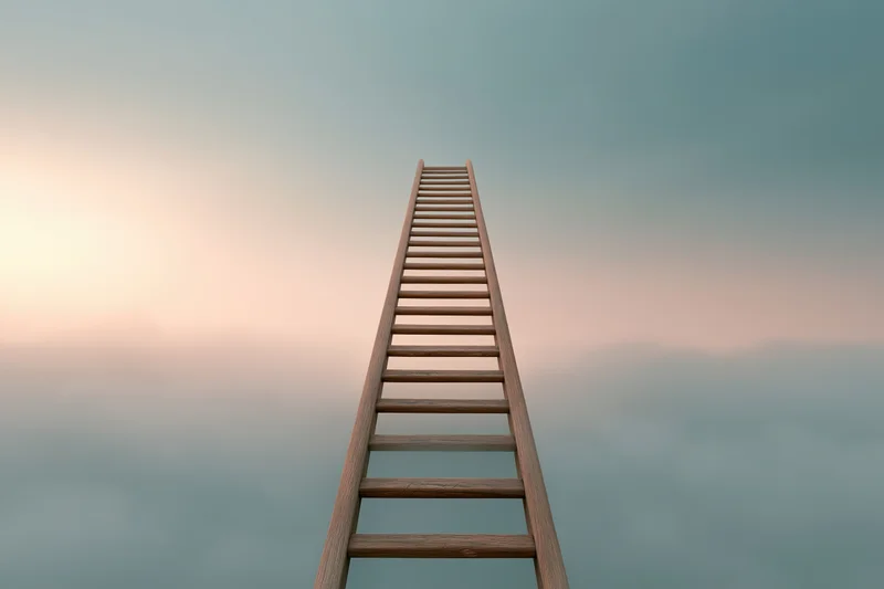 Wooden ladder rising vertically into the sky above soft clouds