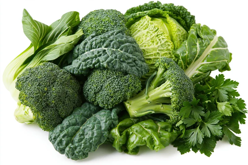 Assorted fresh green vegetables piled together on white background