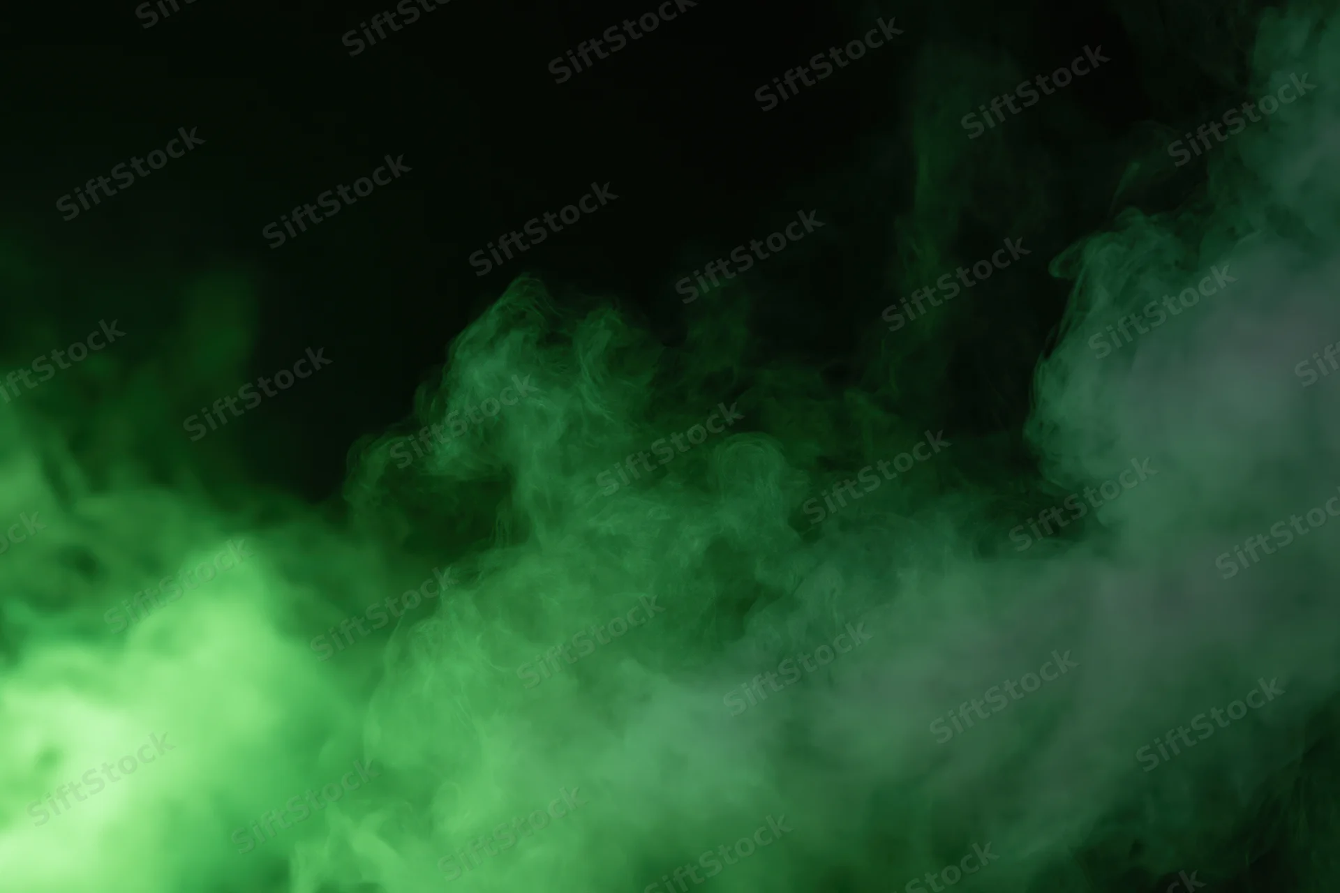 Green smoke drifting upward against a dark background