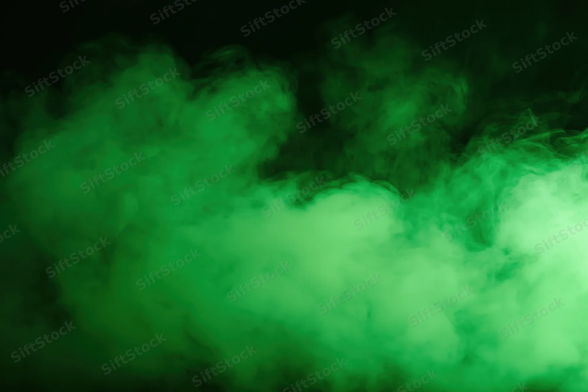 Green smoke drifting upward against a dark background