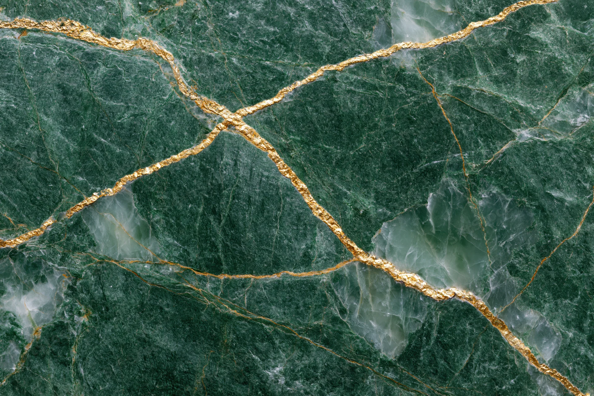 Close-up of deep emerald green marble slab with gold veining and natural texture