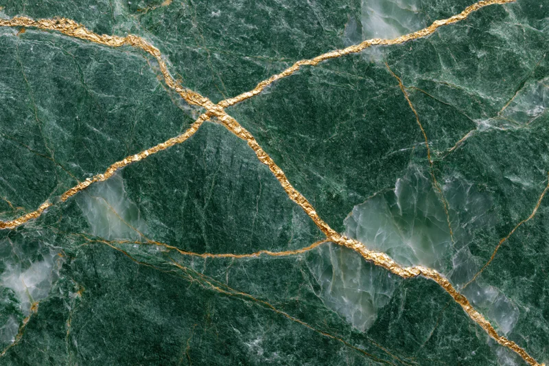 Close-up of deep emerald green marble slab with gold veining and natural texture