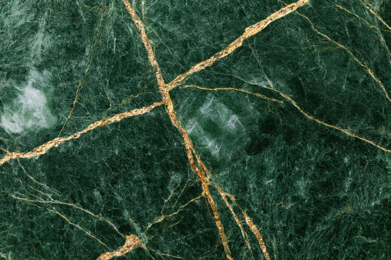 Close-up of deep emerald green marble slab with gold veining and natural texture