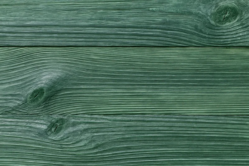 Close-up of green-stained wooden planks showing natural grain and texture
