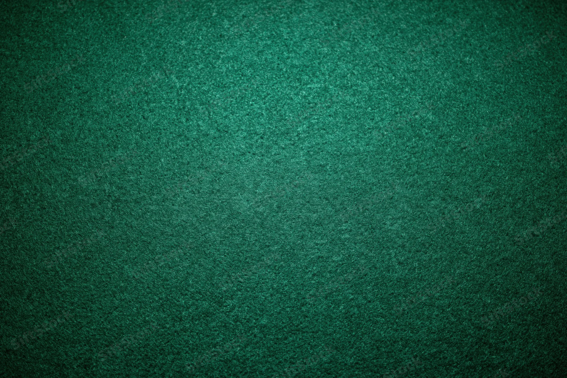 Close-up of green felt poker table surface with textured grain and subtle shadows