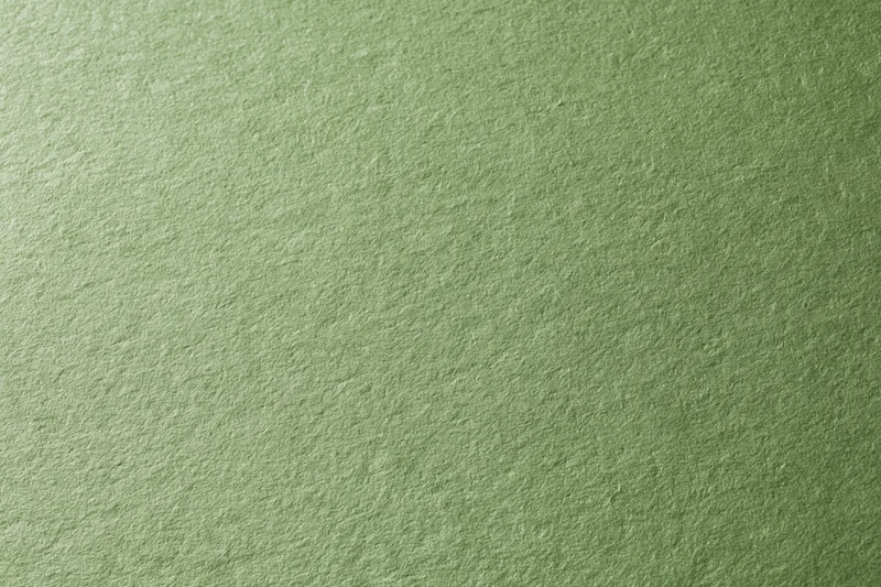 Close-up of muted olive green cardstock surface with textured finish