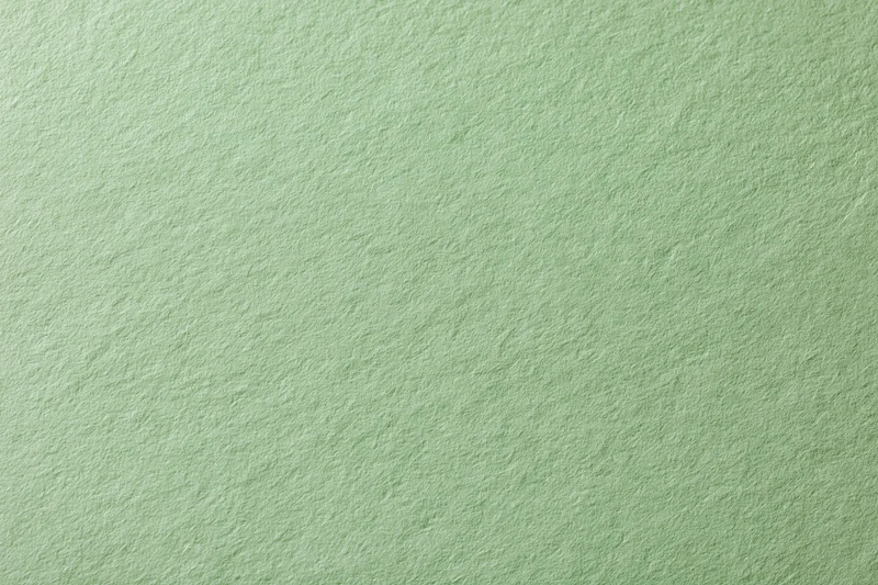 Close-up of sage green cardstock paper surface with textured grain pattern
