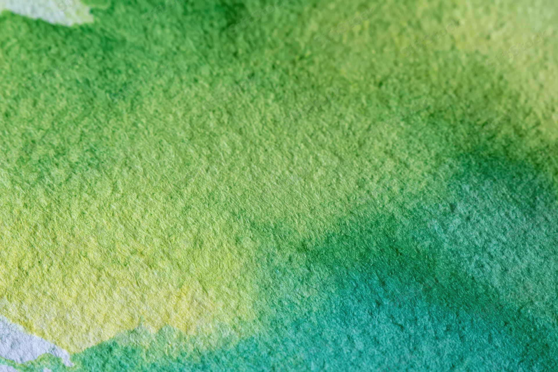 Close-up of watercolor paint blending on textured paper surface