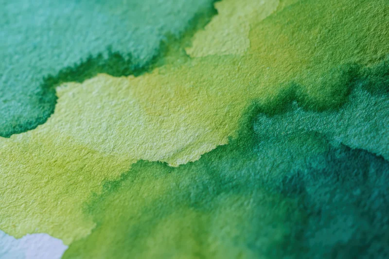 Close-up of watercolor paint blending on textured paper surface