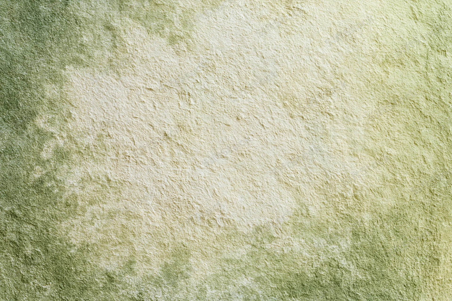 Close-up of aged plaster wall surface with green and beige tones