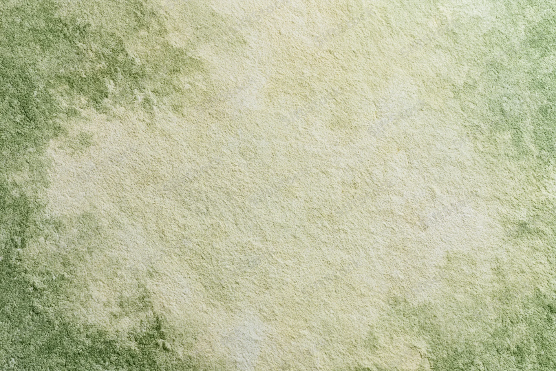 Close-up of aged plaster wall surface with green and beige mottled texture