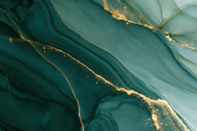Abstract teal and gold alcohol ink art with fluid swirls on paper surface