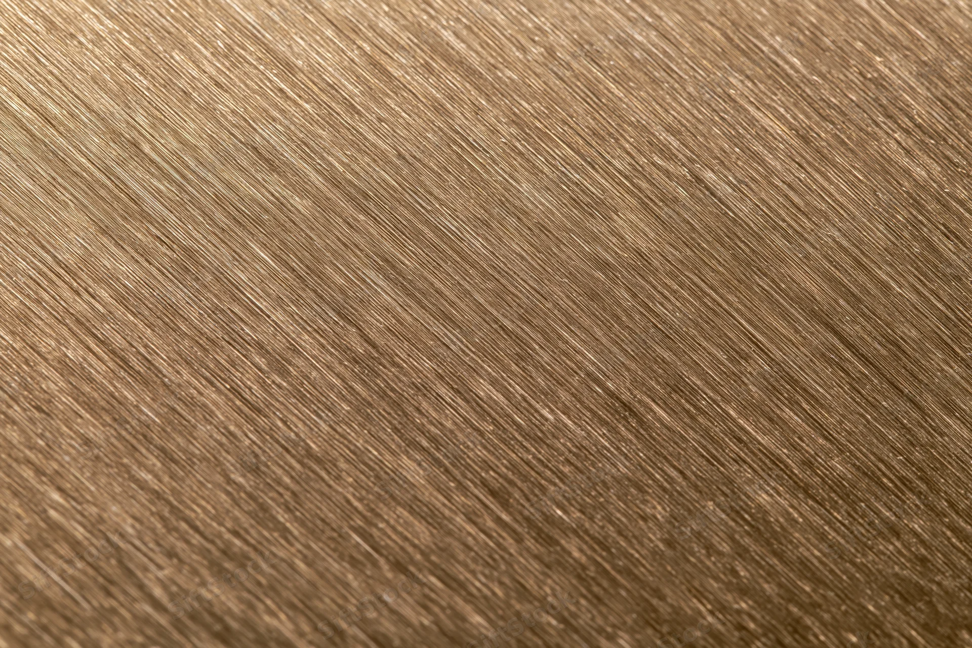 Close-up of brushed bronze metal surface with diagonal texture pattern