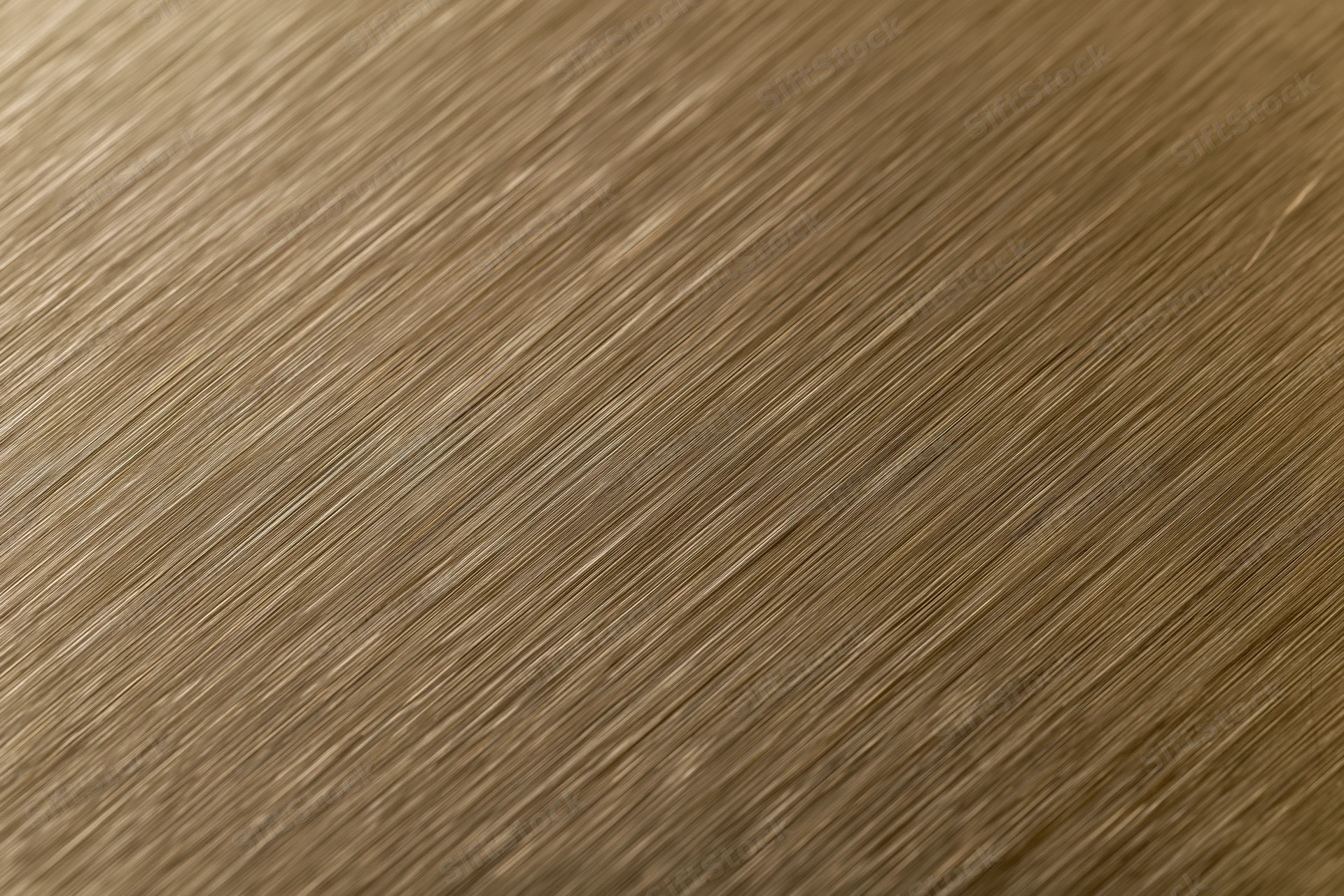Close-up of brushed bronze metal surface with diagonal texture pattern