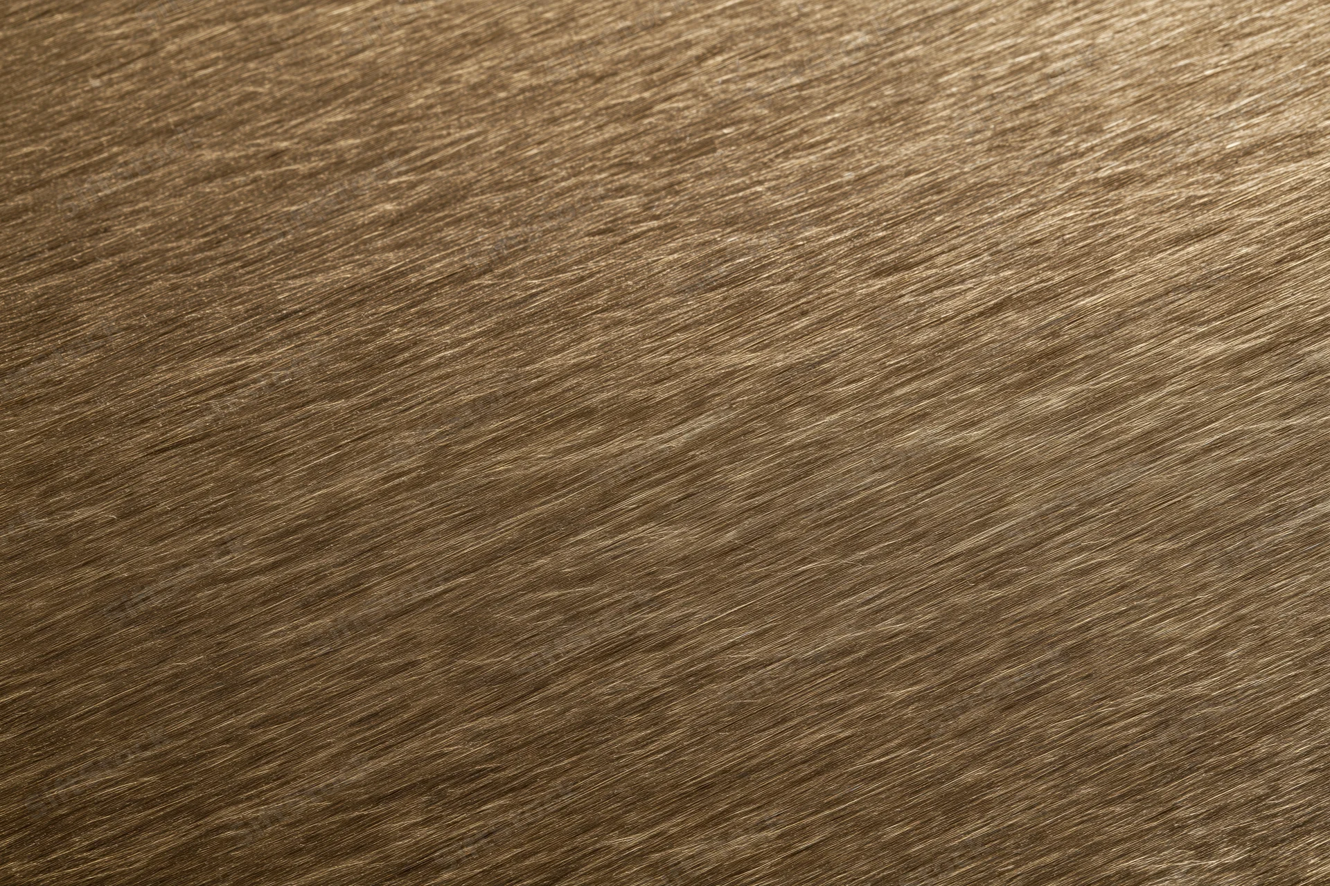 Close-up of brushed bronze metal surface with linear texture filling the frame