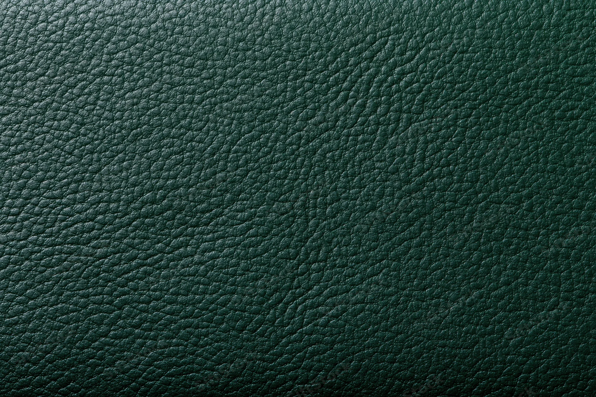 Close-up of dark forest green leather surface showing detailed grain texture