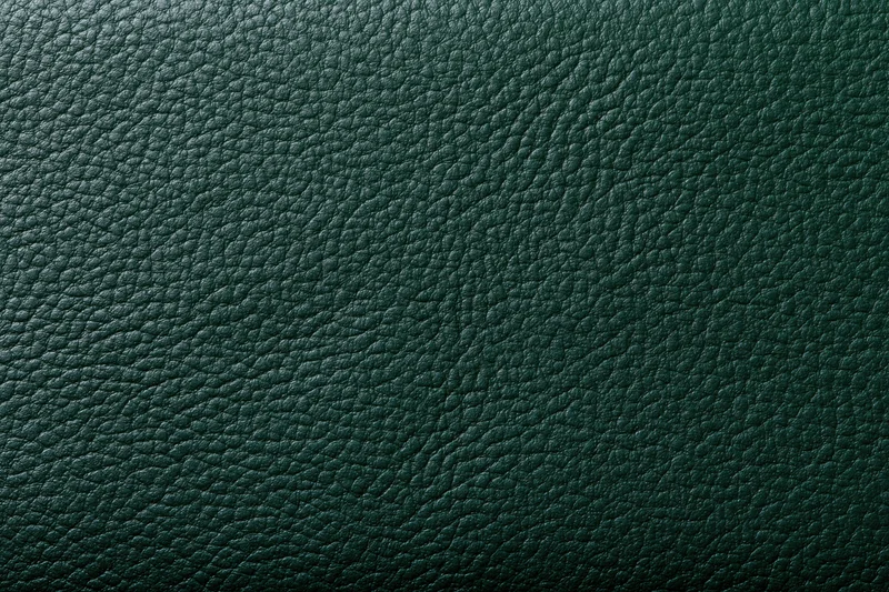 Close-up of dark forest green leather surface showing detailed grain texture