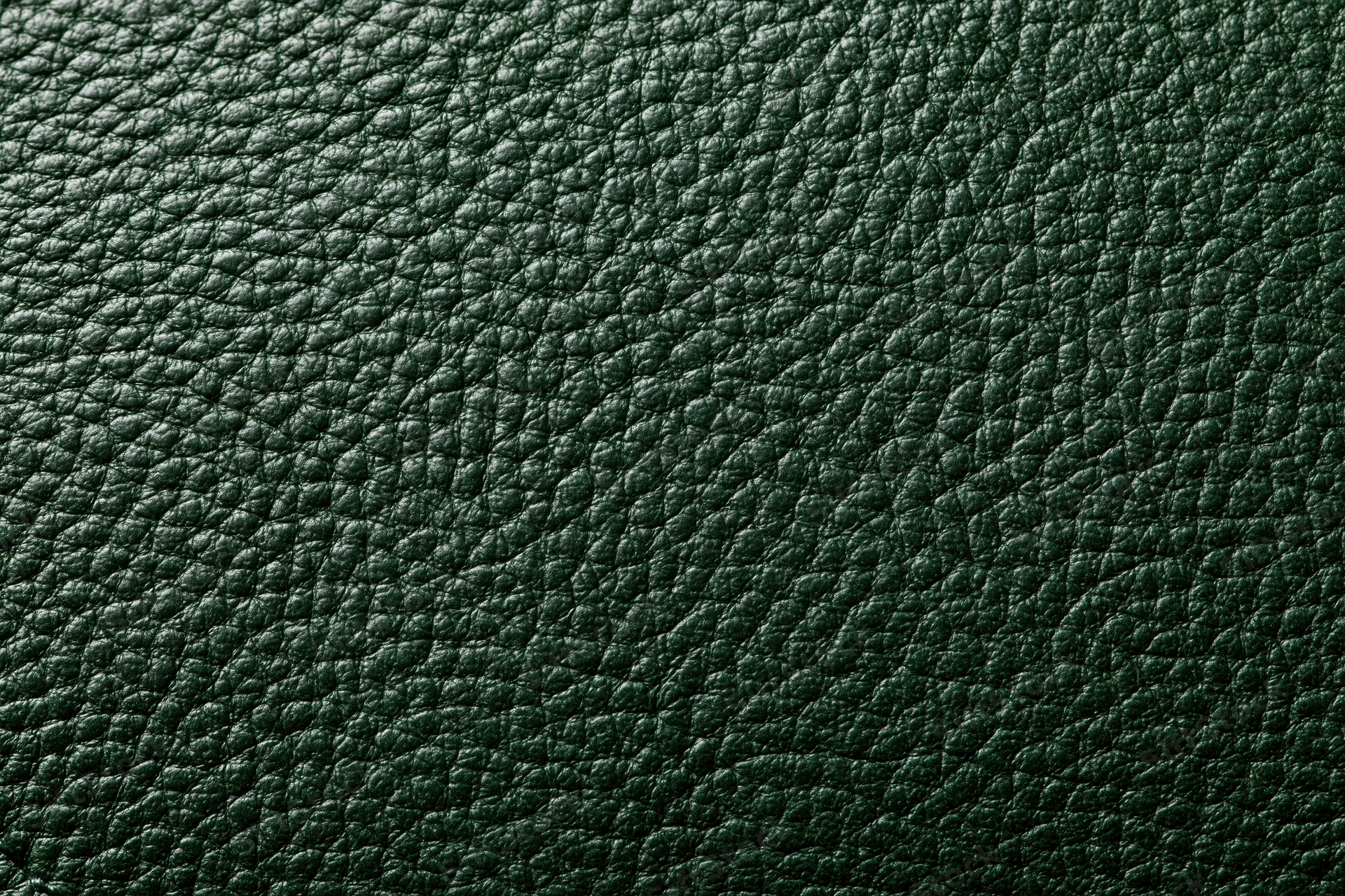 Close-up of dark forest green leather surface with pebbled texture filling the frame