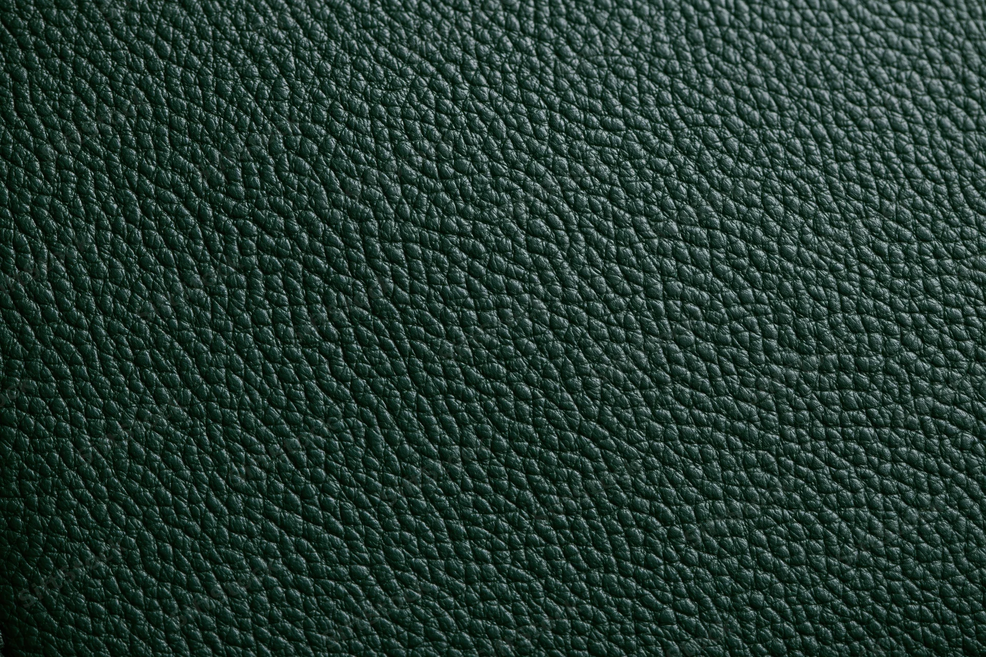 Close-up of dark forest green leather surface showing pebbled texture and grain pattern