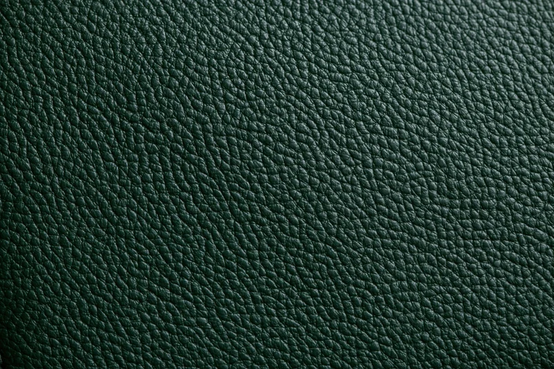 Close-up of dark forest green leather surface showing pebbled texture and grain pattern