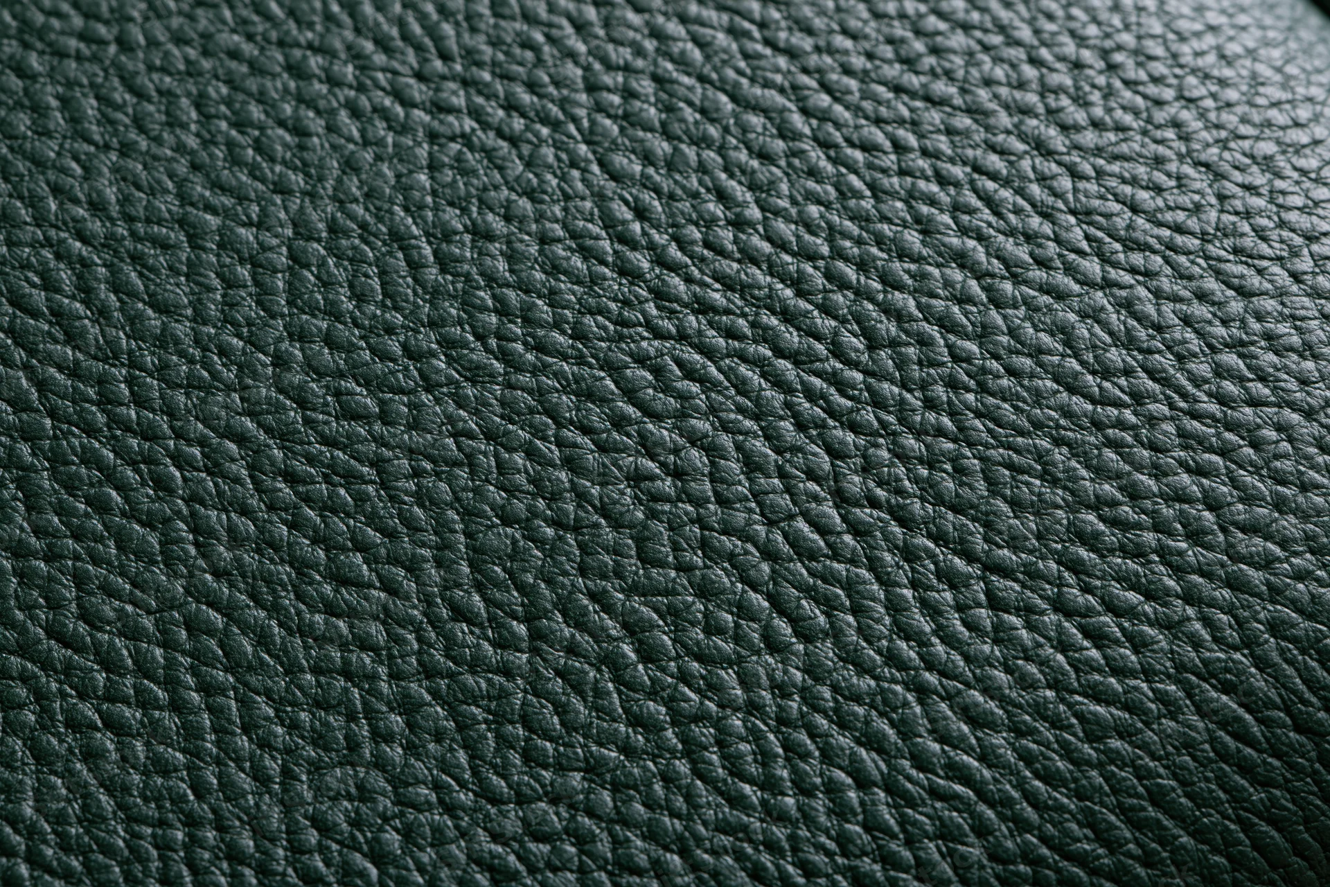 Close-up of dark forest green leather surface with pebbled texture filling the frame